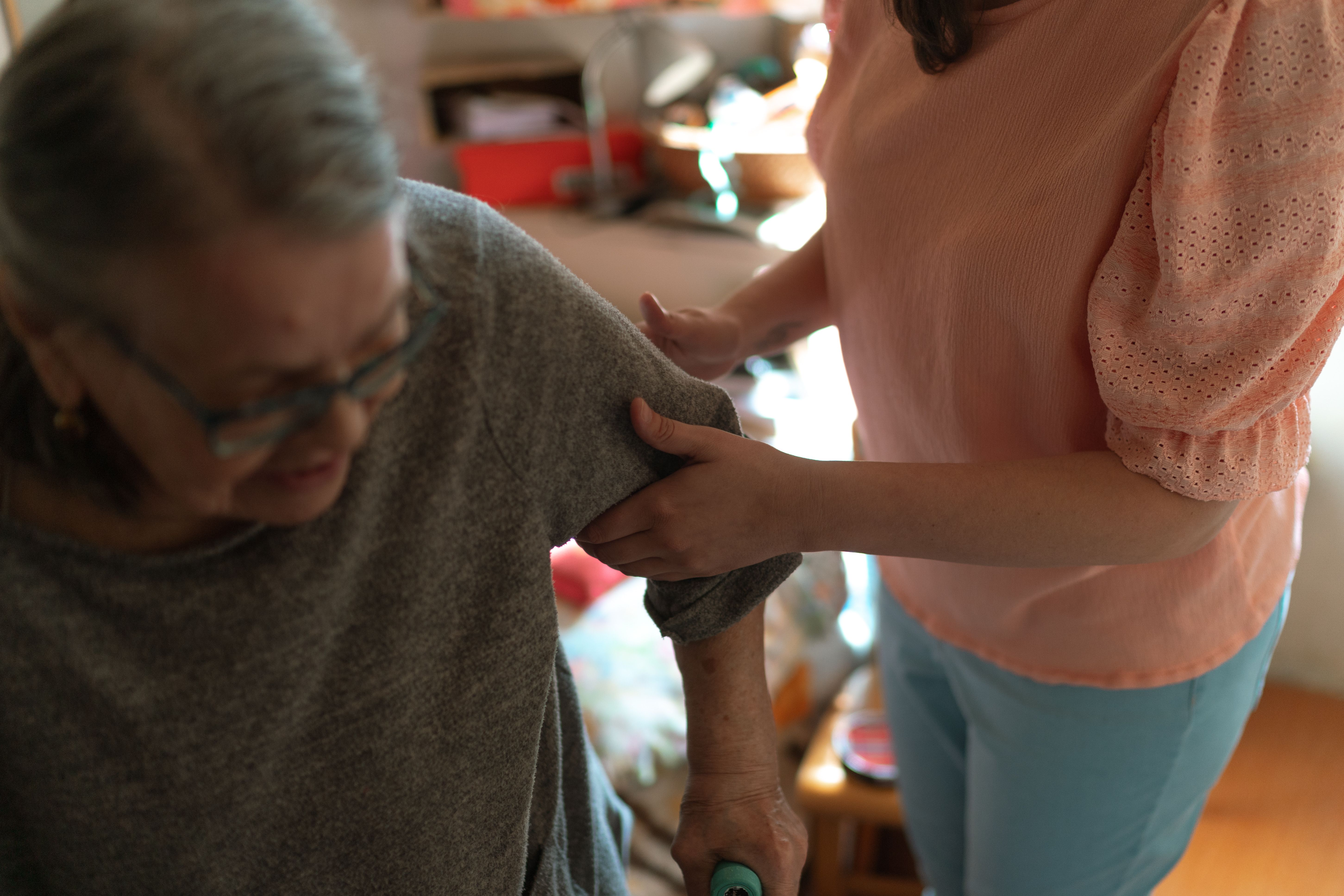 Care worker listening to an older woman in her home