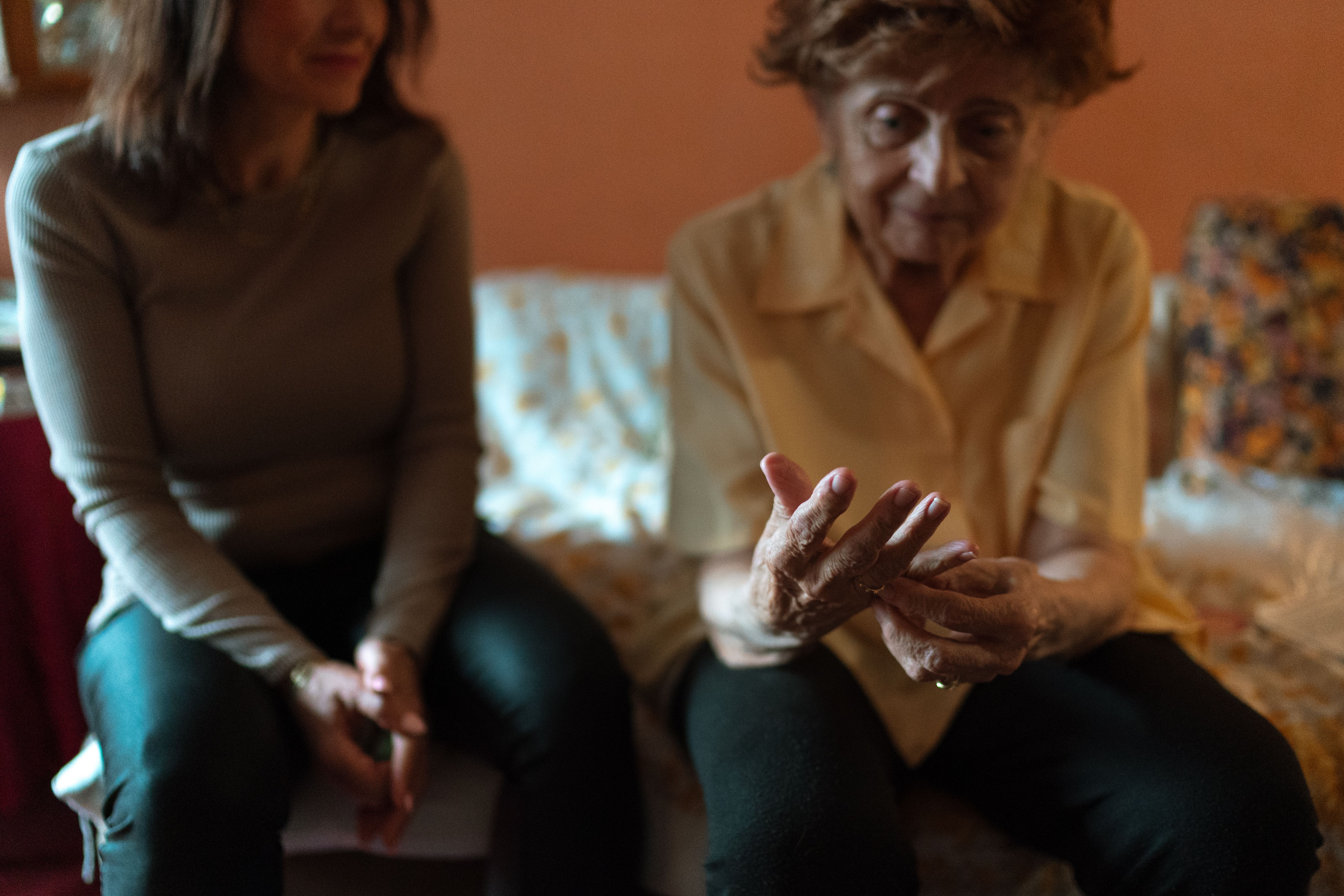 Care worker having a warm conversation with an older woman at home
